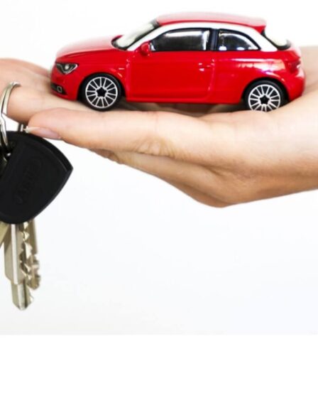 mano-tiene-chiavi-auto-e-auto-in-miniatura