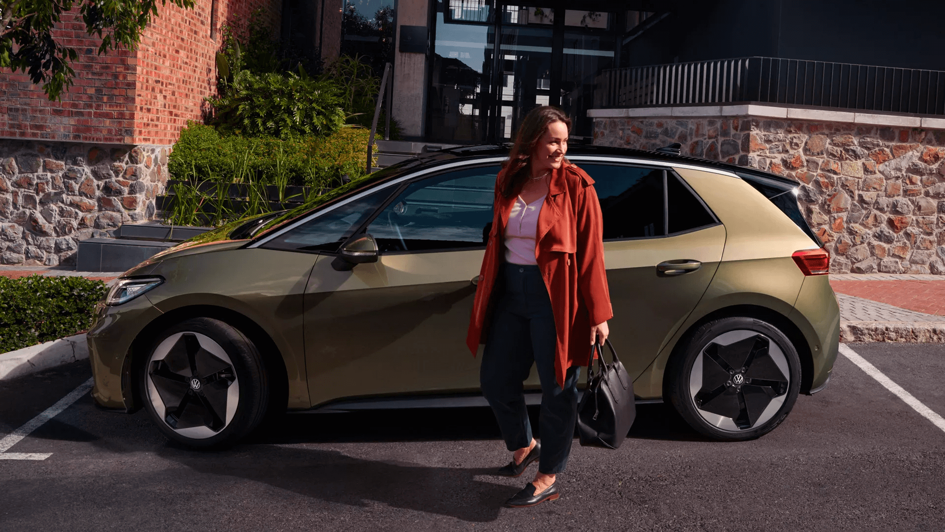 donna-sorridente-vicino-auto-volkswagen-sfondo-casa